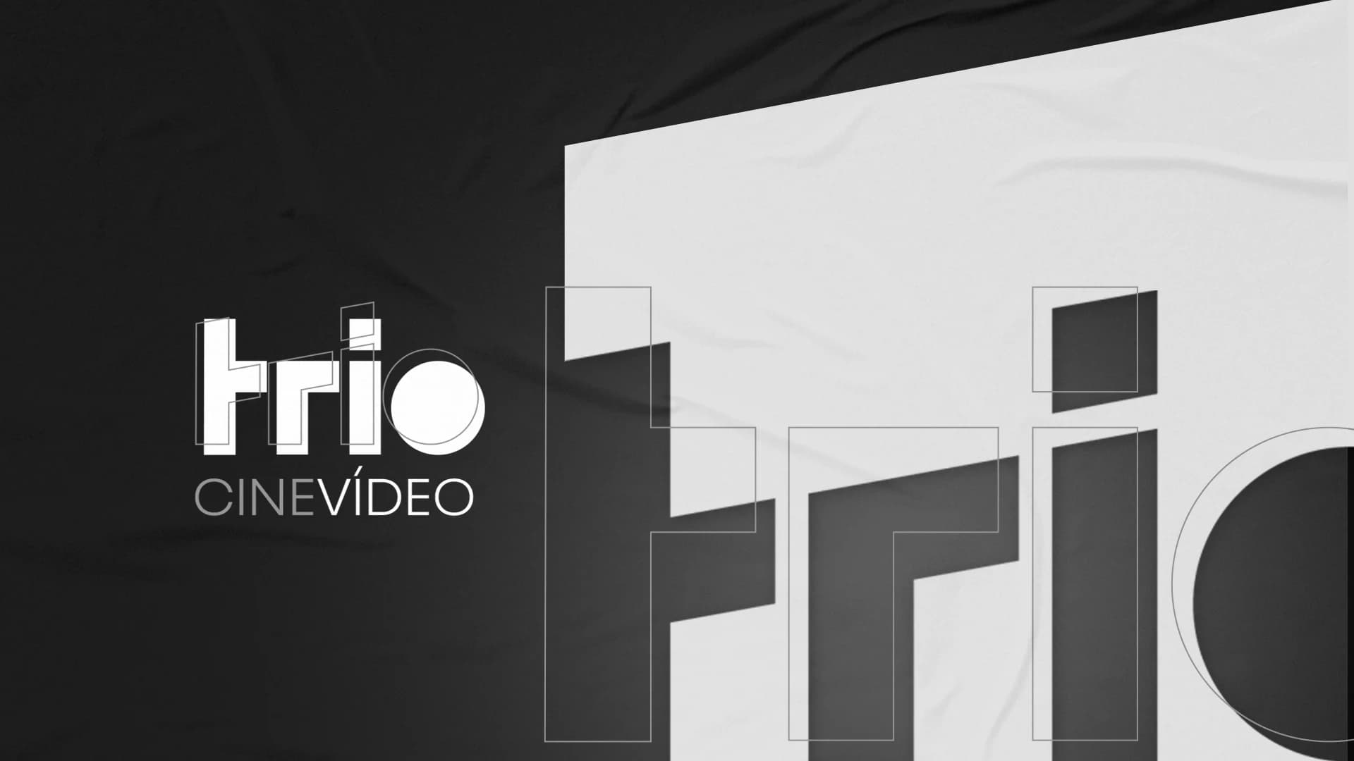 Logotipo TRIO Cine Vídeo em branco sobre tecido preto, ao lado do padrão gráfico da marca ampliado em tecido claro