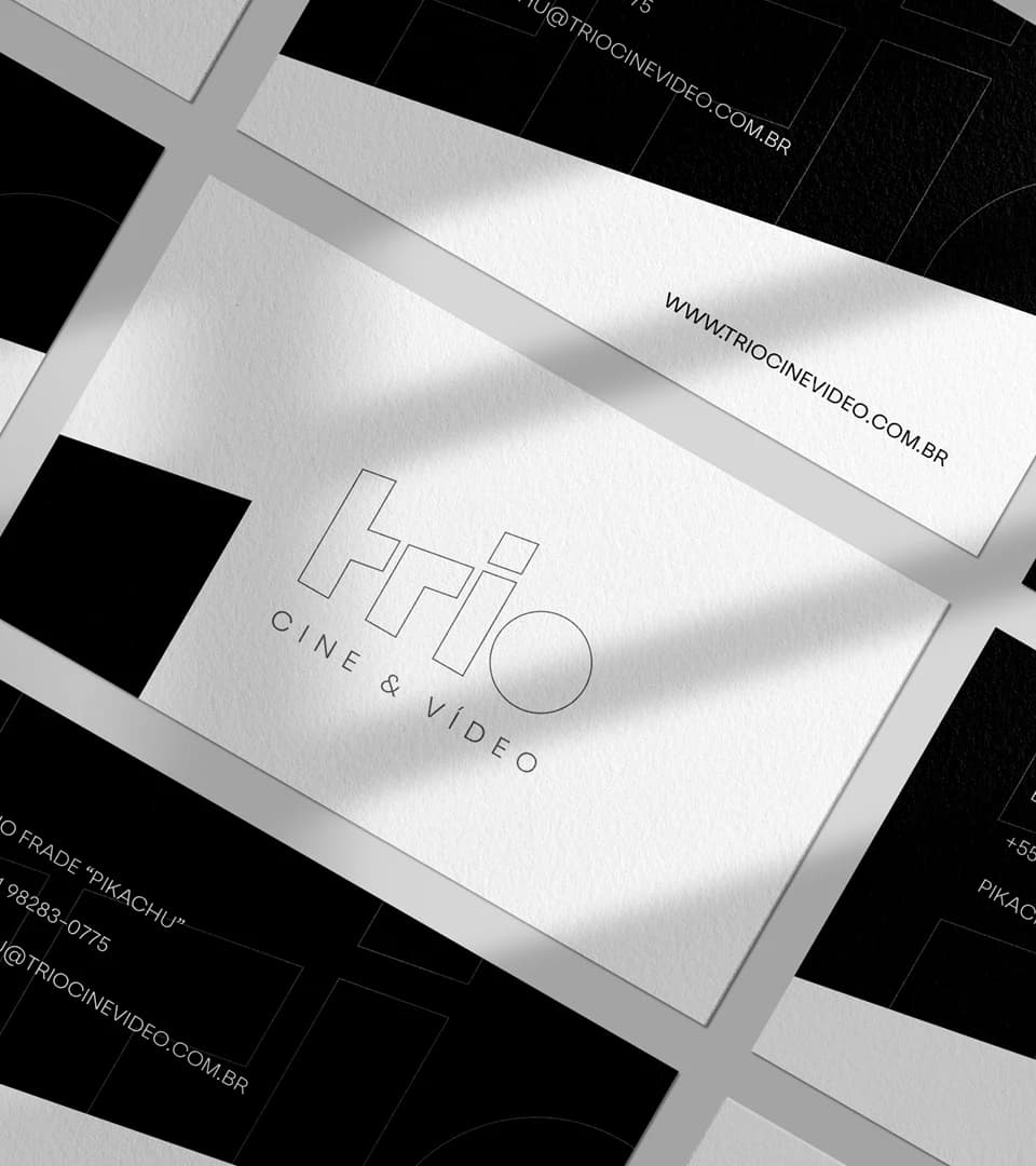 Cartões de visita em papel branco texturizado com o logotipo em linha, sobre cartões pretos com os contatos